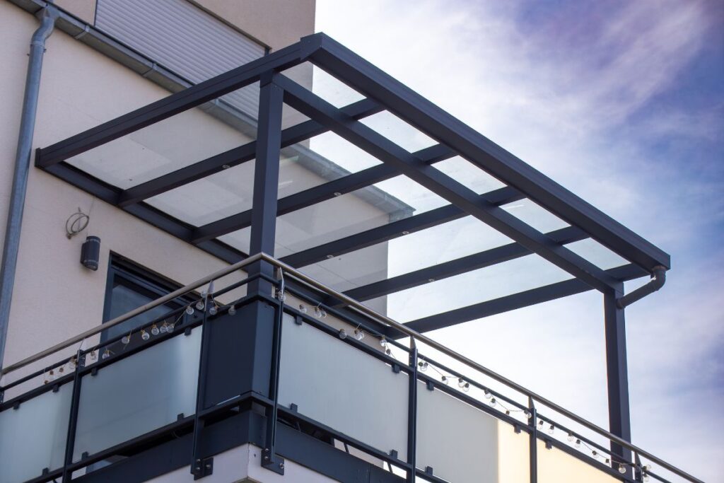 Moderne Glasüberdachung mit pulverbeschichtetem Stahlrahmen – individuelle Glaslösung für Balkon in der Steiermark, kombiniert mit Metallkonstruktion