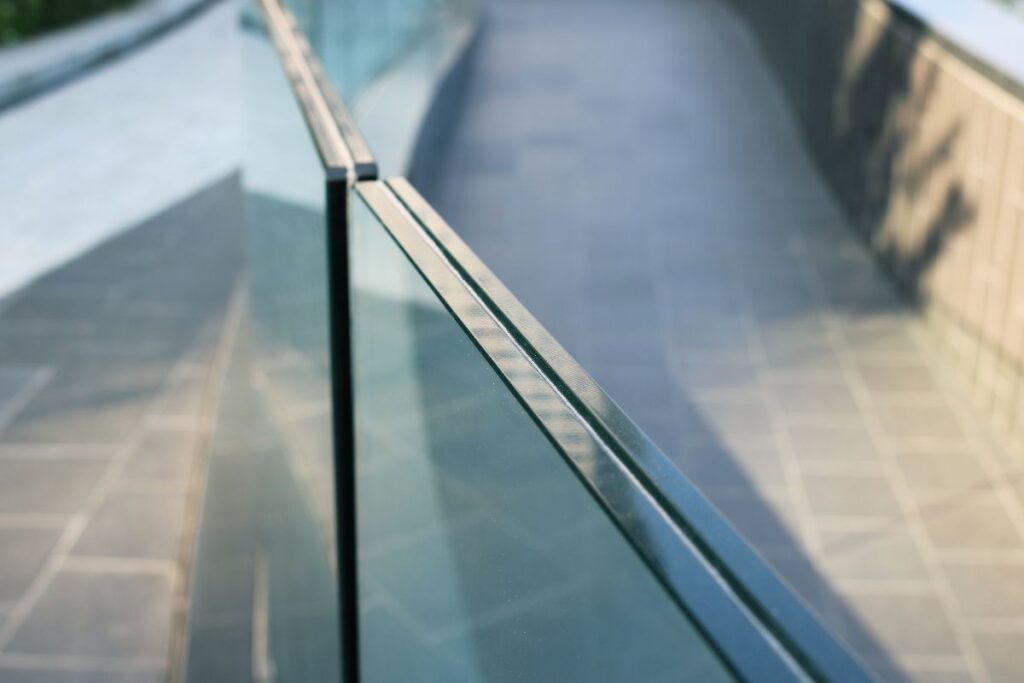 Detailansicht eines Handlaufs mit Glasverkleidung – maßgefertigtes Ganzglasgeländer für moderne Innenräume in der Steiermark
